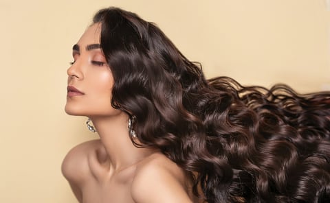 Woman with long dark hair and clear, healthy skin